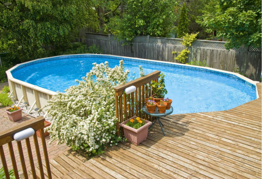 above ground pool with trees plants and wooden planks